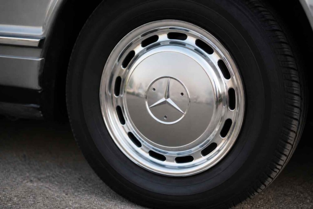 Zbliżenie na chromowane koło samochodu Mercedes z emblematem na centralnym kołpaku