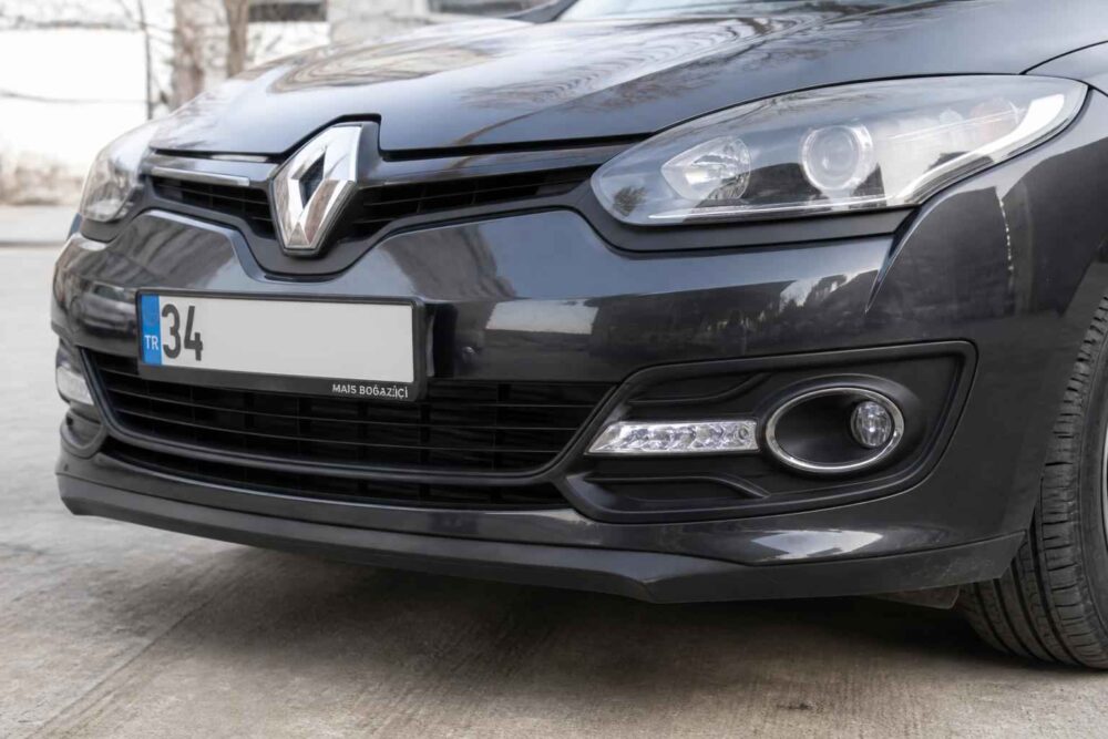 Czarny Renault Megane z bliska Przód czarnego Renault Megane z reflektorem, światłami LED i tablicą rejestracyjną 34 na parkingu